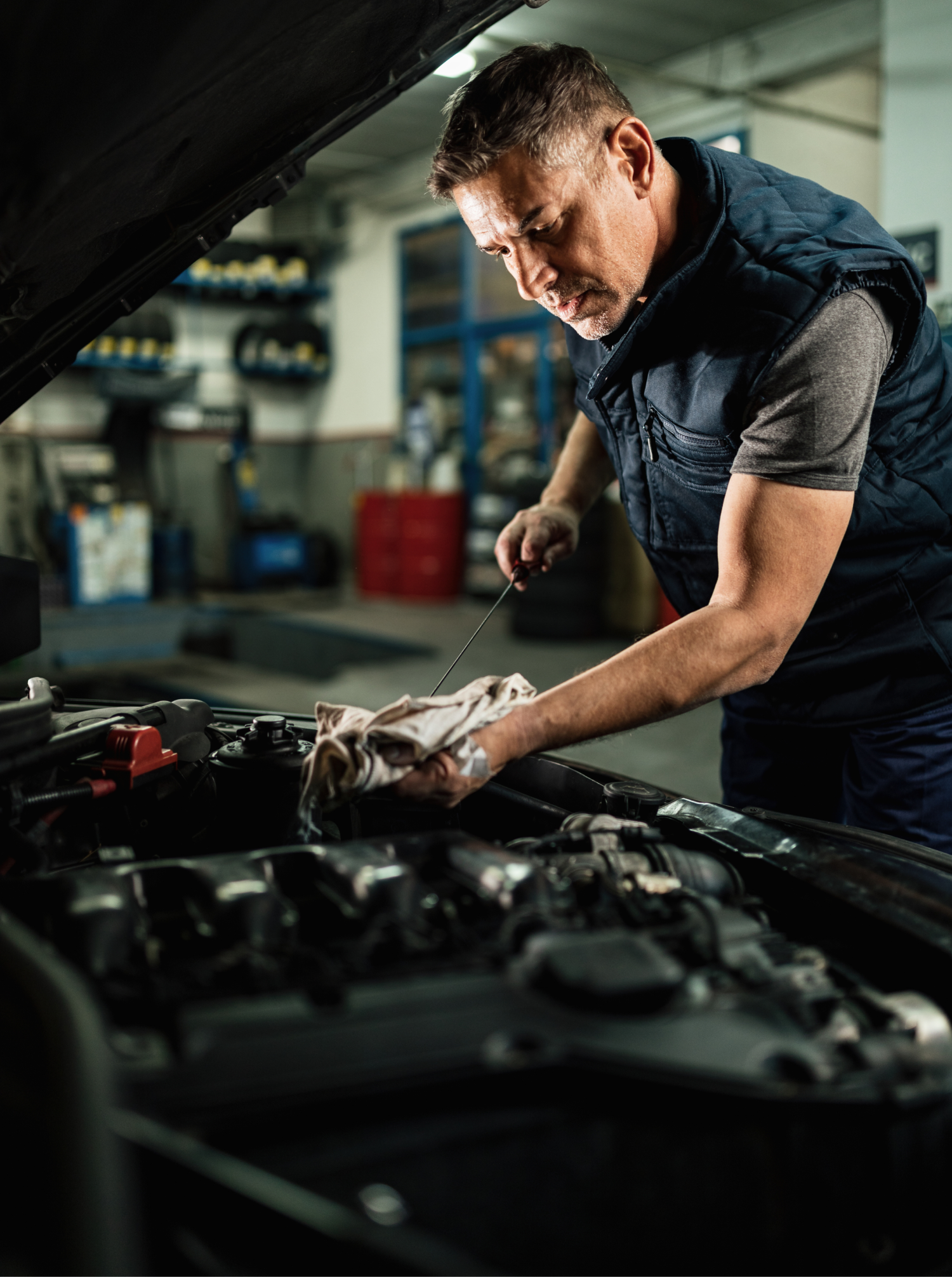 Auto mechanic checking oil in a car engine. Auto mechanic checking oil in a car engine.