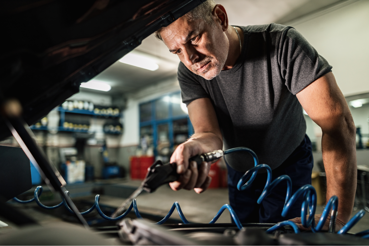 Mechanic cleaning a car engine with an air gun. Mechanic cleaning a car engine with an air gun.